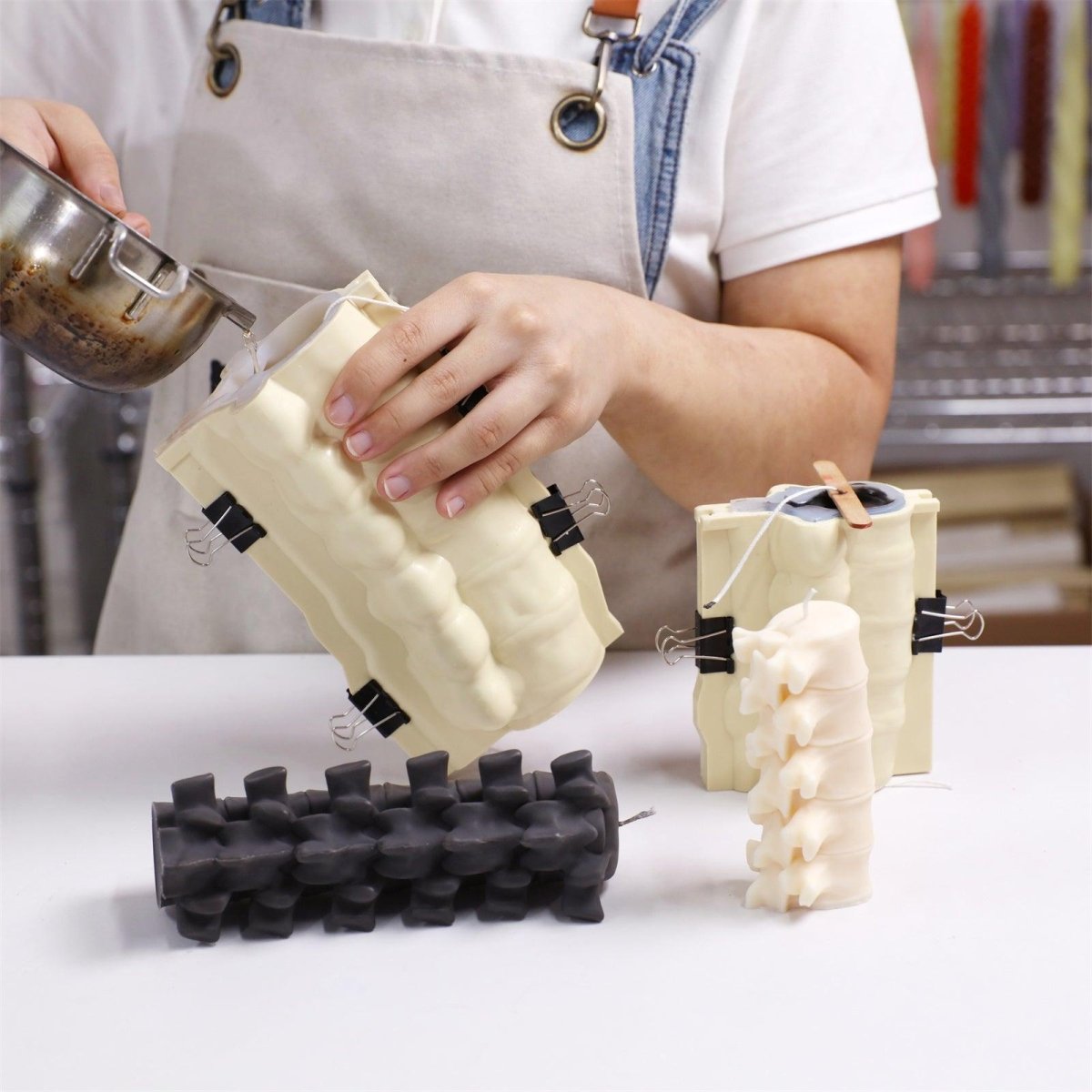 Pouring wax into spine candle mold with support shell - Boowan Nicole
