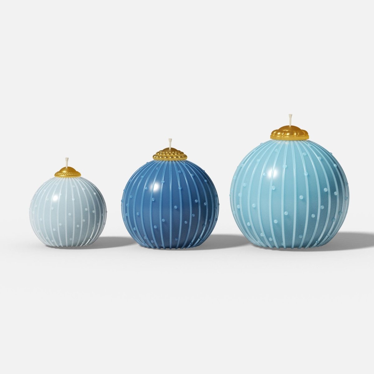 Set of three blue Christmas bauble candles (S/M/L) with vertical stripe-dot texture, gold caps, and glossy finish on white background - Boowan Nicole