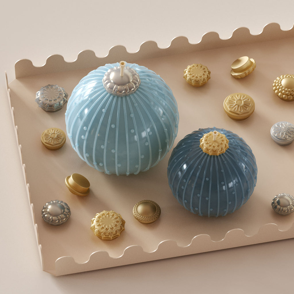Blue bauble candles with stripe-dot texture on a scalloped tray, surrounded by gold and silver ornament topper caps—interchangeable accessories - Boowan Nicole