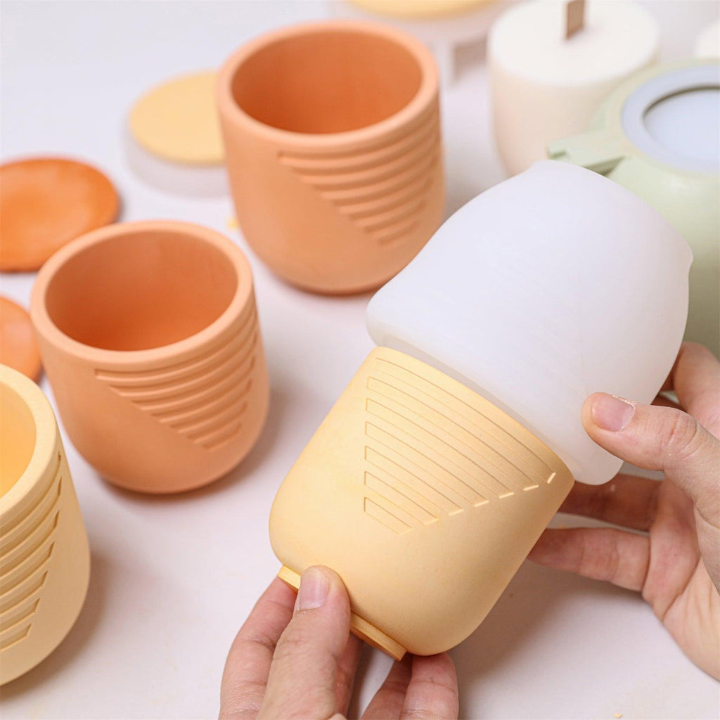 Hands unmolding a yellow geometric candle jar from a silicone mold - Boowan Nicole