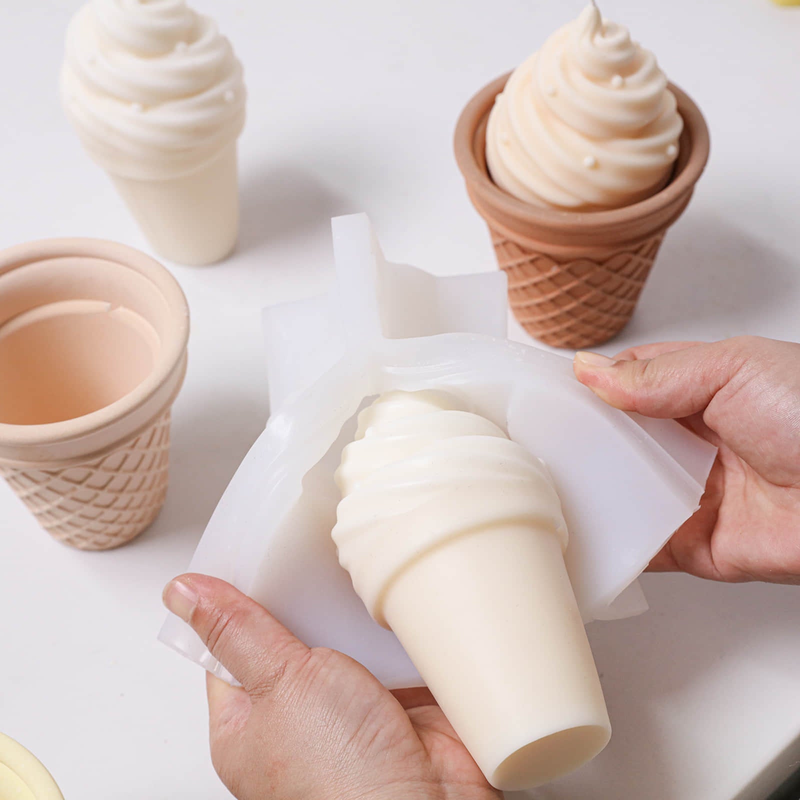 Hands demolding a soft-serve ice cream cone swirl candle from the Sweet Swirl Sundae silicone mold - Boowan Nicole