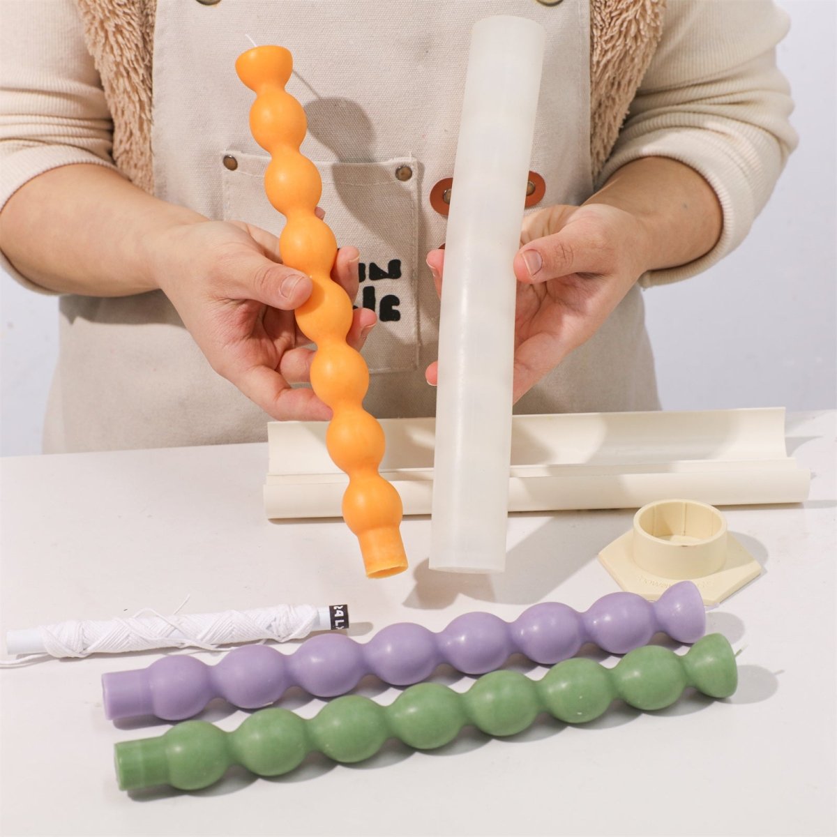 Displaying the orange taper candle after demolding from the candle silicone mold-Boowan Nicole