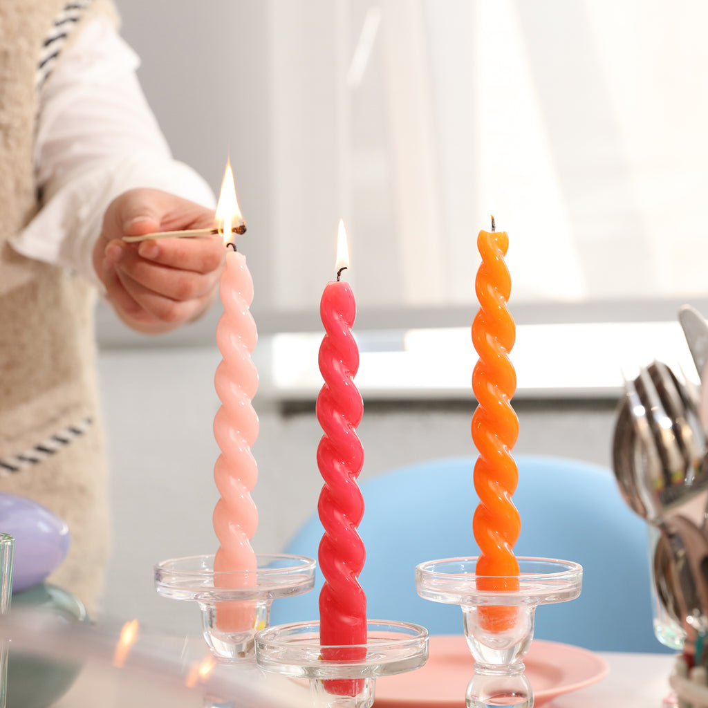 Light the orange, red and pink tapered spiral candles on the candle holder - Boowan Nicole
