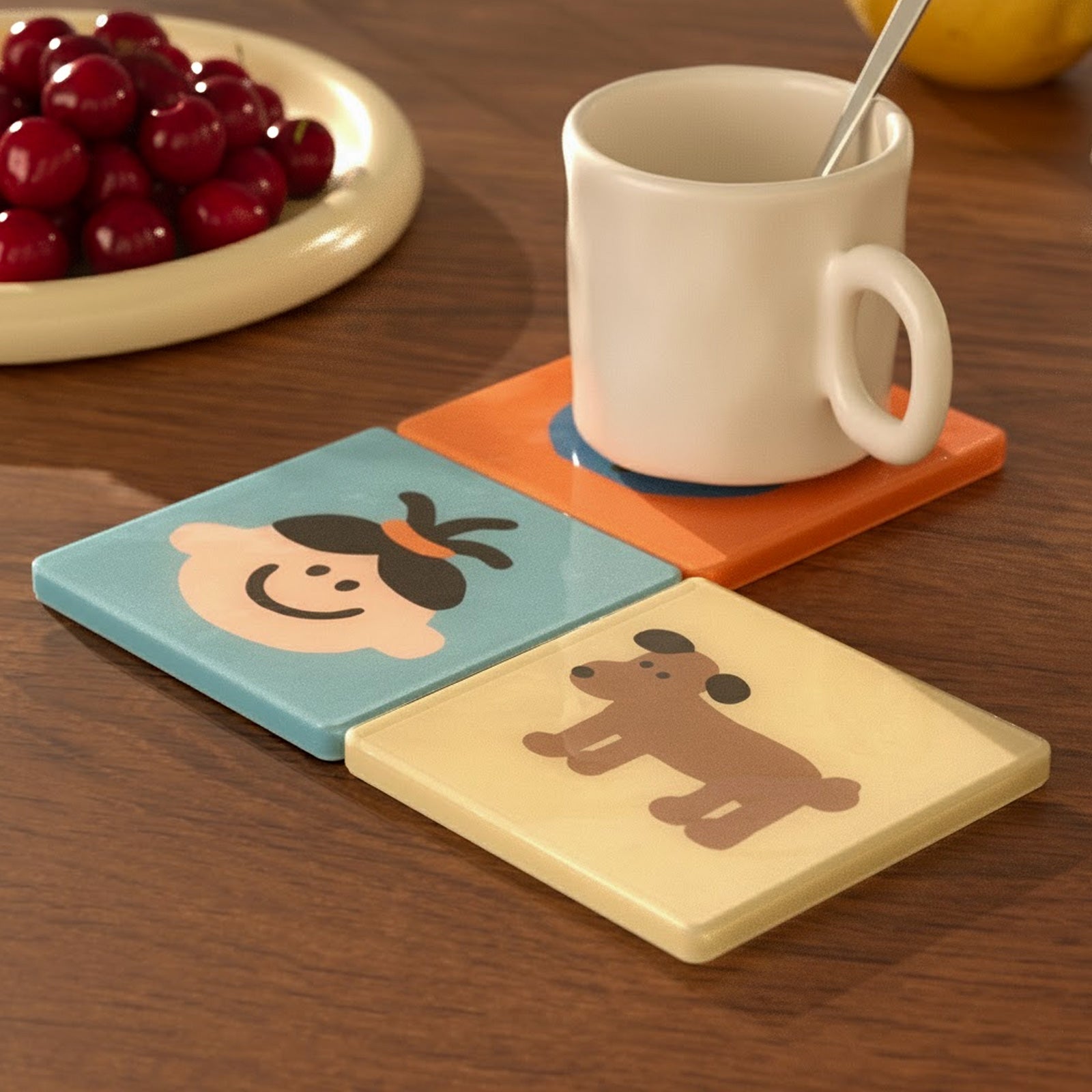 Colorful square coasters with cute face and dog illustrations holding a white coffee mug on a wooden table - Boowan Nicole