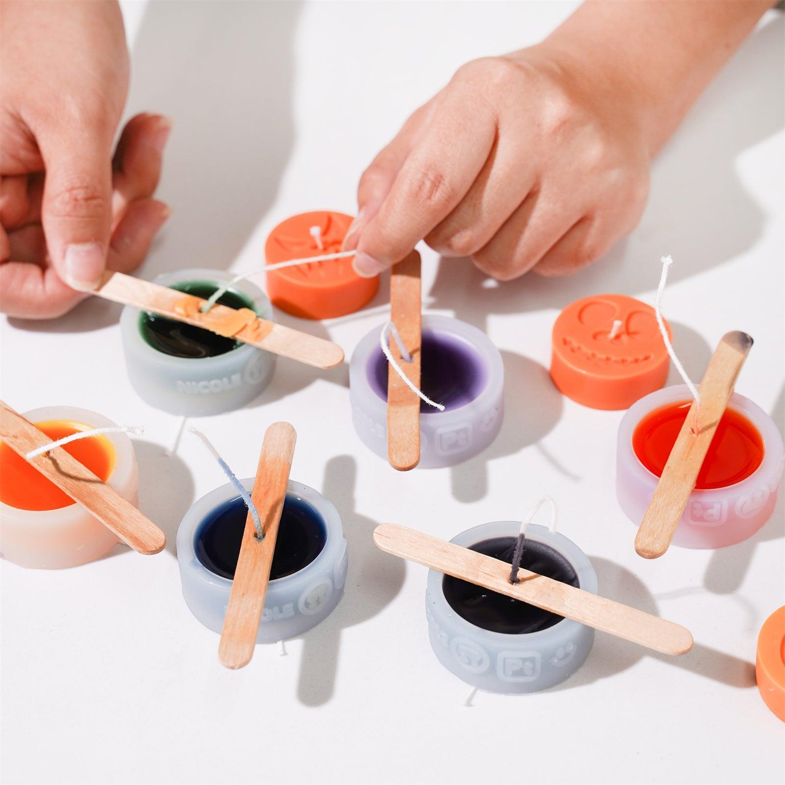 Fixing the wicks of ghostly grinning teacup candles with different expressions using ice cream sticks - Boowan Nicole