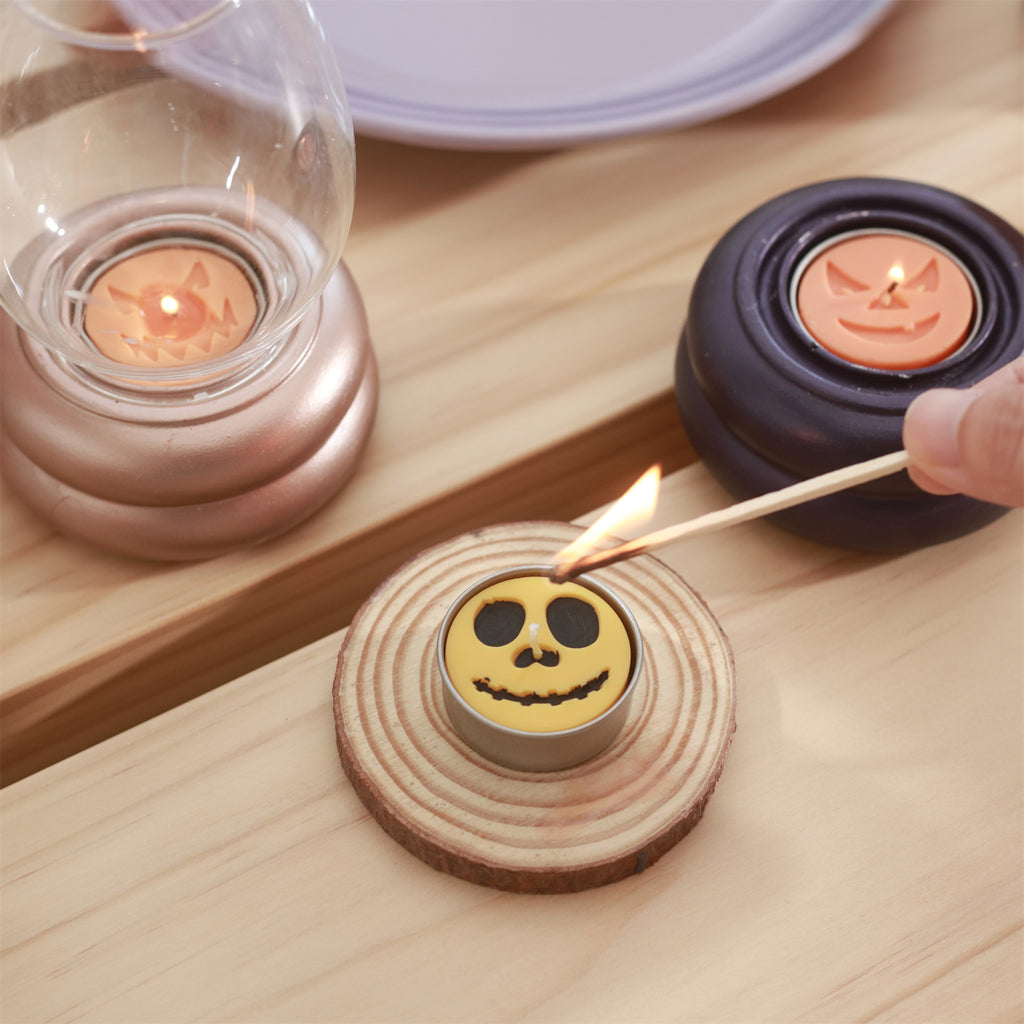 Lighting the yellow hand-painted Haunted Grins tealight candle - Boowan Nicole