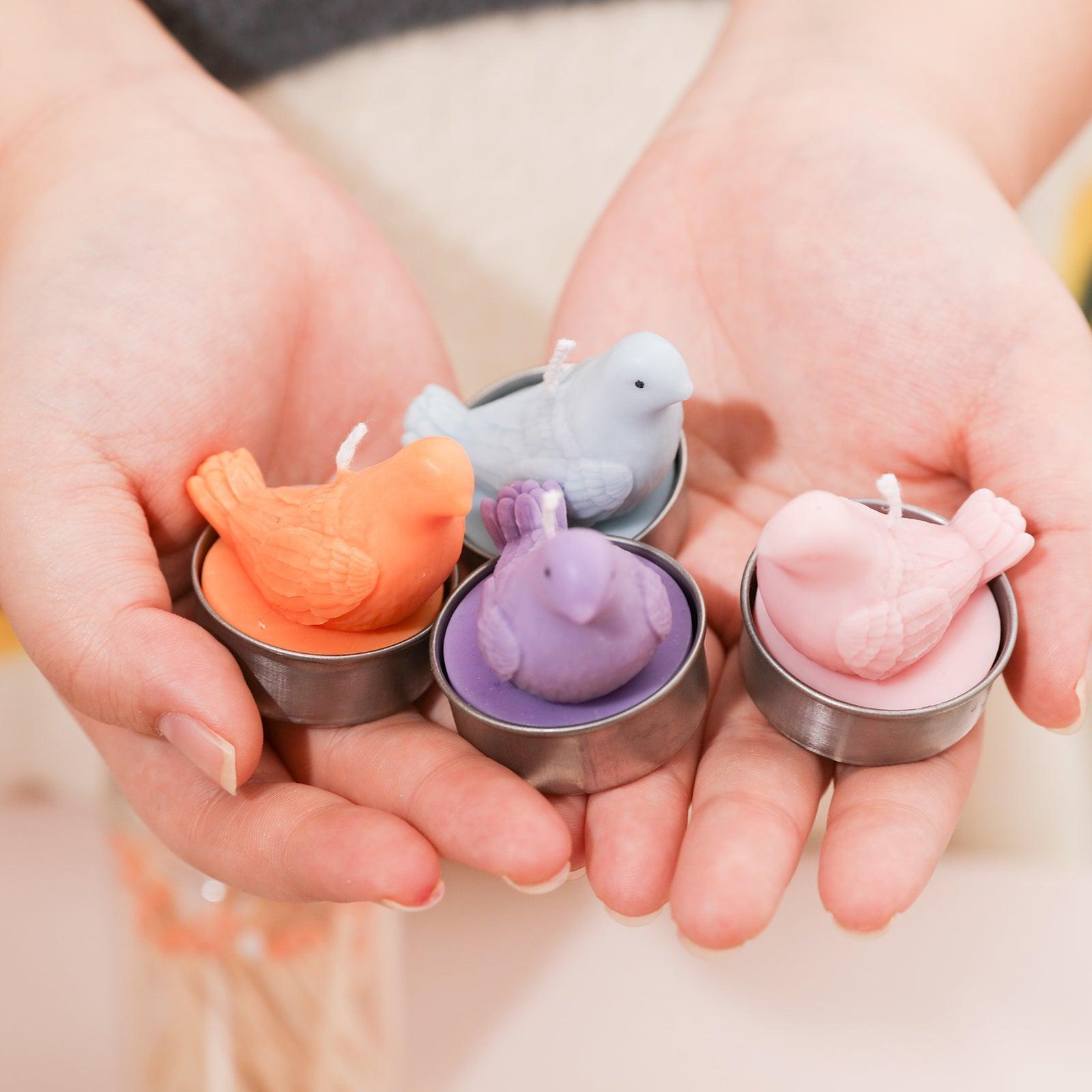 Holding the orange, purple, blue and pink peace dove shaped tea light candles in your hand, the design is exquisite and pays attention to details, designed by Boowan Nicole.