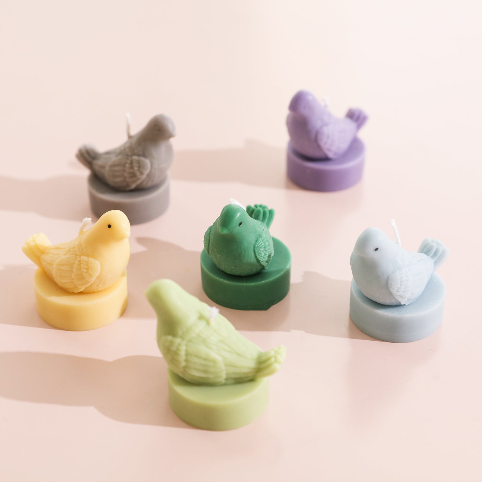 Six tea light candles in the shape of peace doves of different colors are placed on the table. The shapes reflect flexibility and are designed by Boowan Nicole.