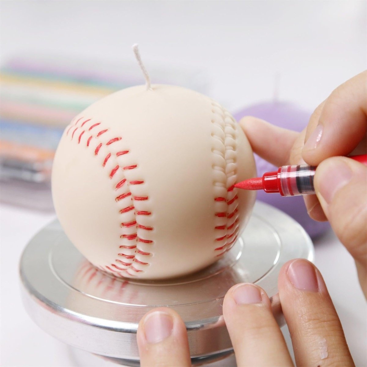 decorating the baseball candle with wax pen