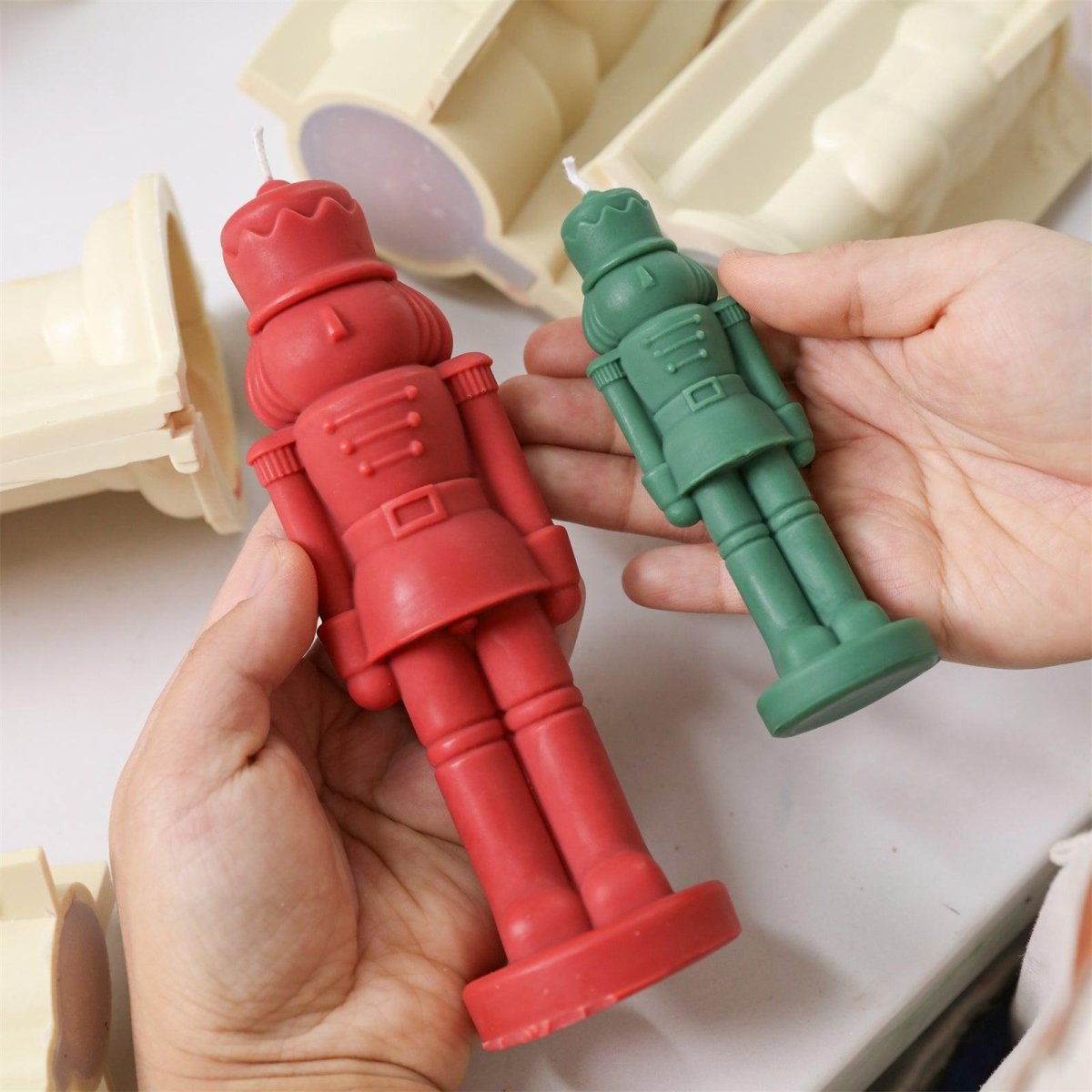 Holding freshly unmolded red and green nutcracker candles with crisp, refined details - Boowan Nicole