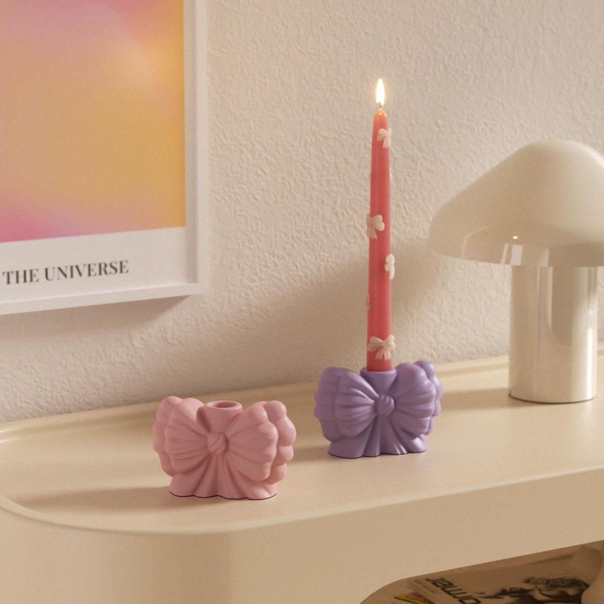 Purple and pink bow-shaped candle holders with decorative taper candle on a modern shelf – handmade home decor - Boowan Nicole