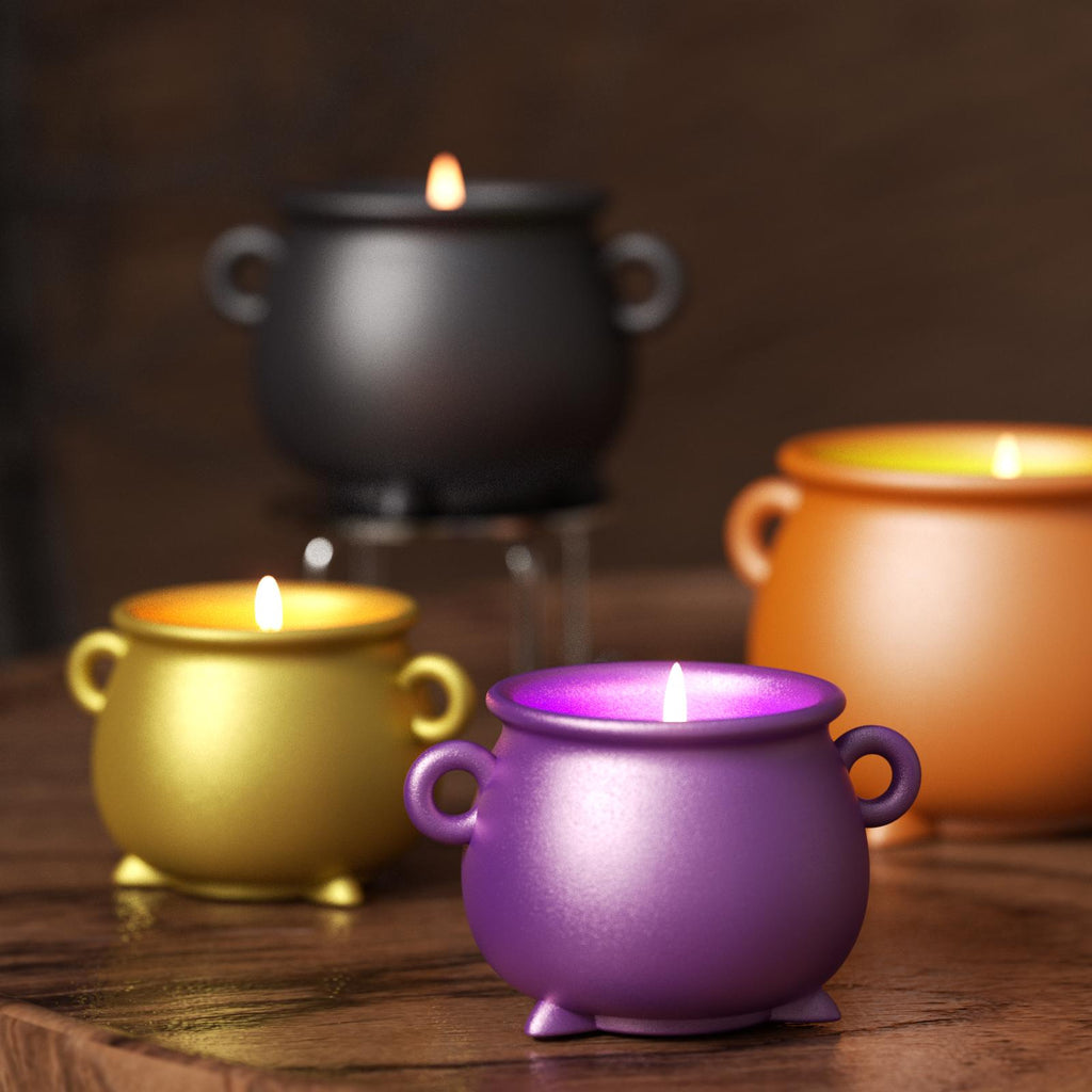 Colorful cauldron-shaped candles in purple, gold, black, and orange, lit on a wooden surface for a festive display - Boowan Nicole