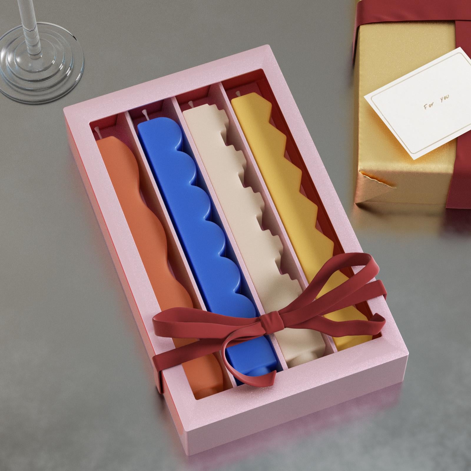 Gift box of four zigzag taper candles—orange wave, blue scallop, beige step, yellow zigzag—tied with ribbon - Boowan Nicole