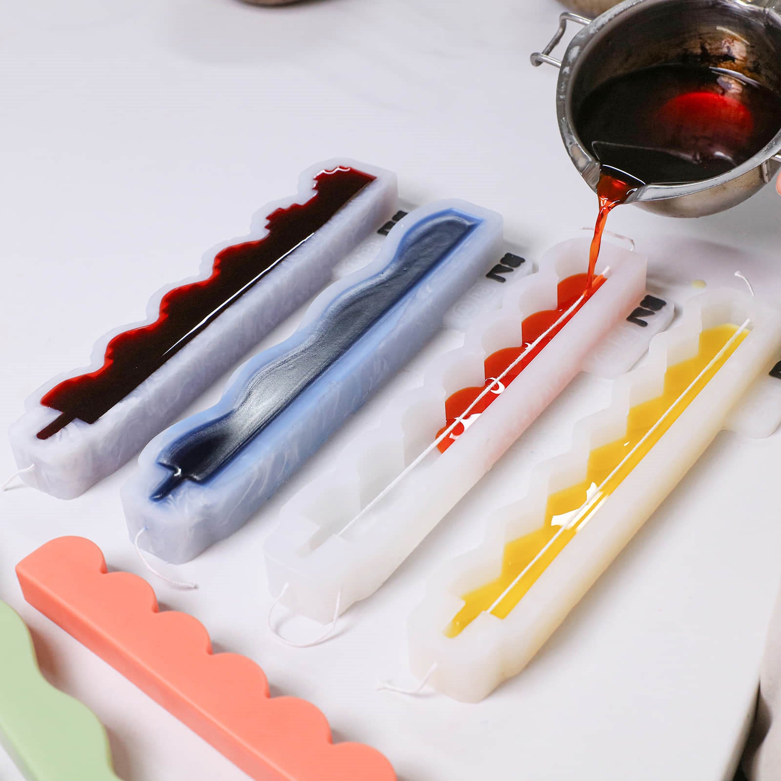 Pouring colored wax into zigzag taper candle silicone molds - Boowan Nicole
