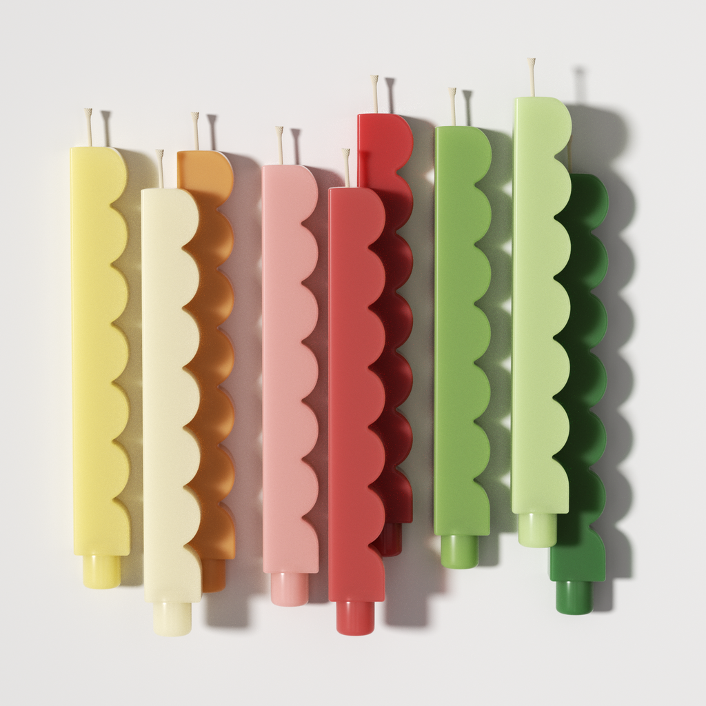 Pastel scalloped-edge taper candles flat lay in yellow, cream, pink, red, and green - Boowan Nicole