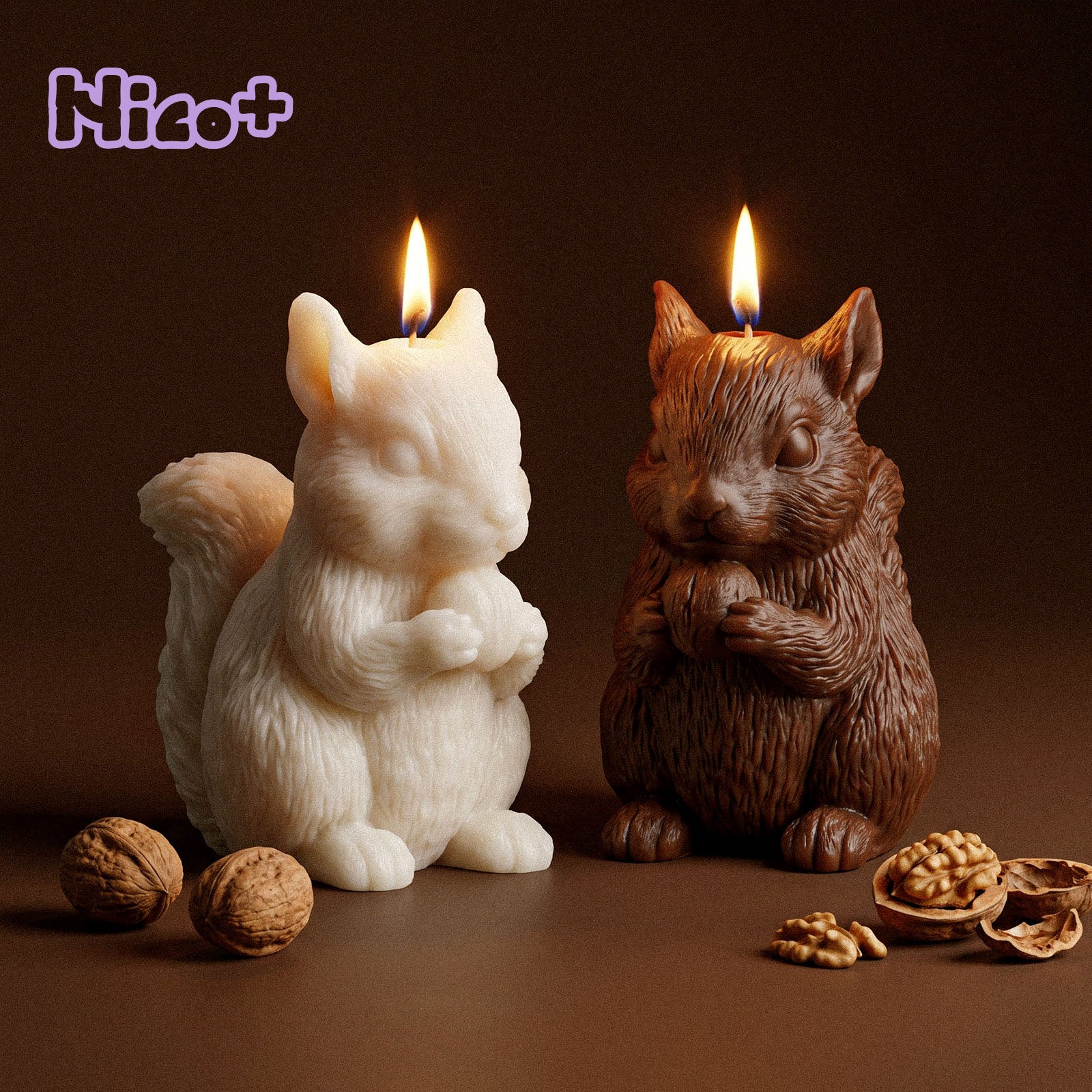 Two Acorn Hug Squirrel Candles burning side by side, one ivory and one brown, each holding a walnut, with whole and cracked walnuts scattered on a dark brown surface, Nico+ collaboration logo in the corner.