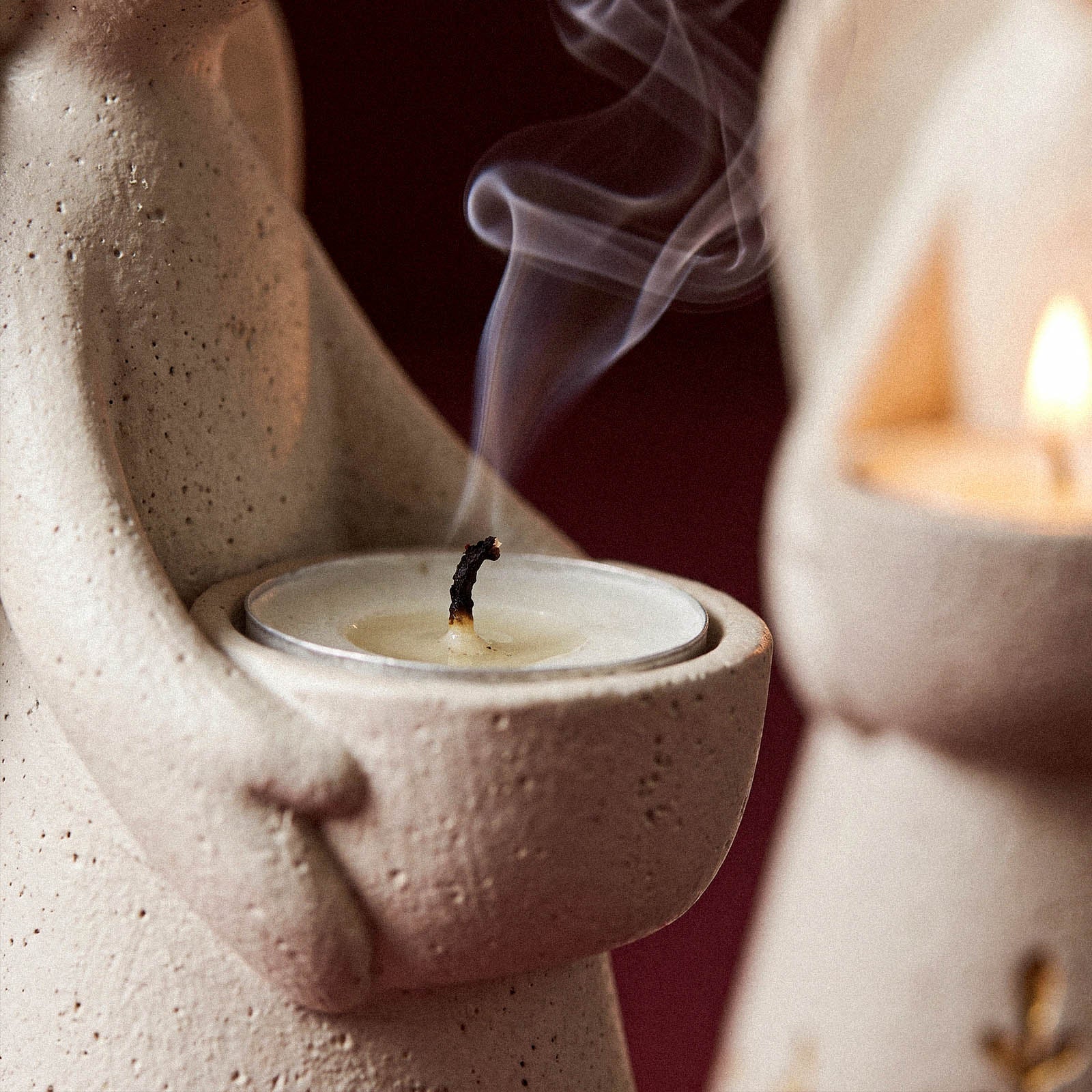 Close-up of the Angel of Light Tealight Holder silicone mold showing a lit tealight candle cradled in the angel's hands with rising smoke