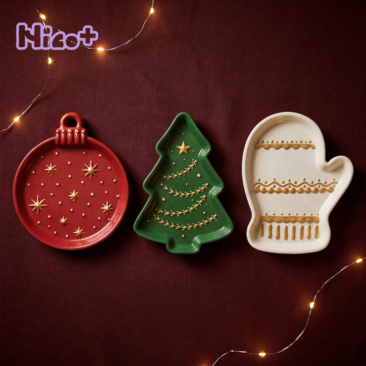 Red ornament, green Christmas tree and cream mitten cement trays with gold painted details on a burgundy holiday tablecloth