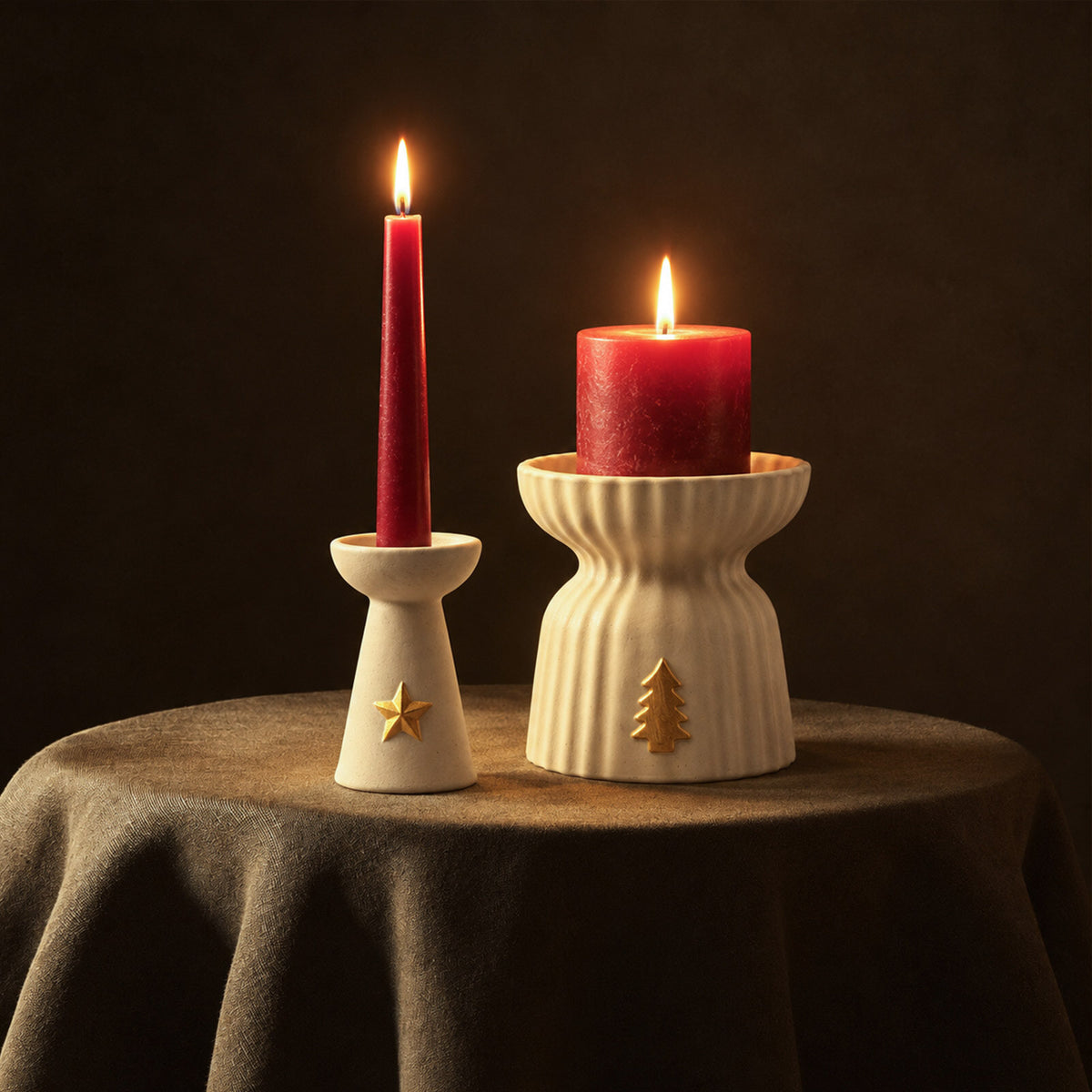 Star charm taper holder and ribbed tree charm pillar holder with lit red candles on a green tablecloth