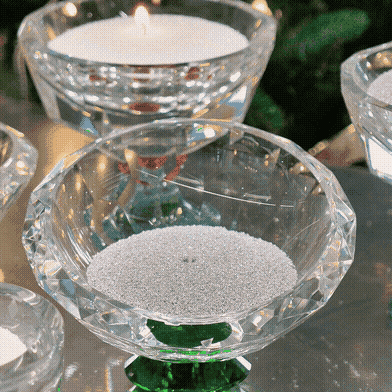 Crystal glass bowl filled with white pearl sand wax and a lit candle