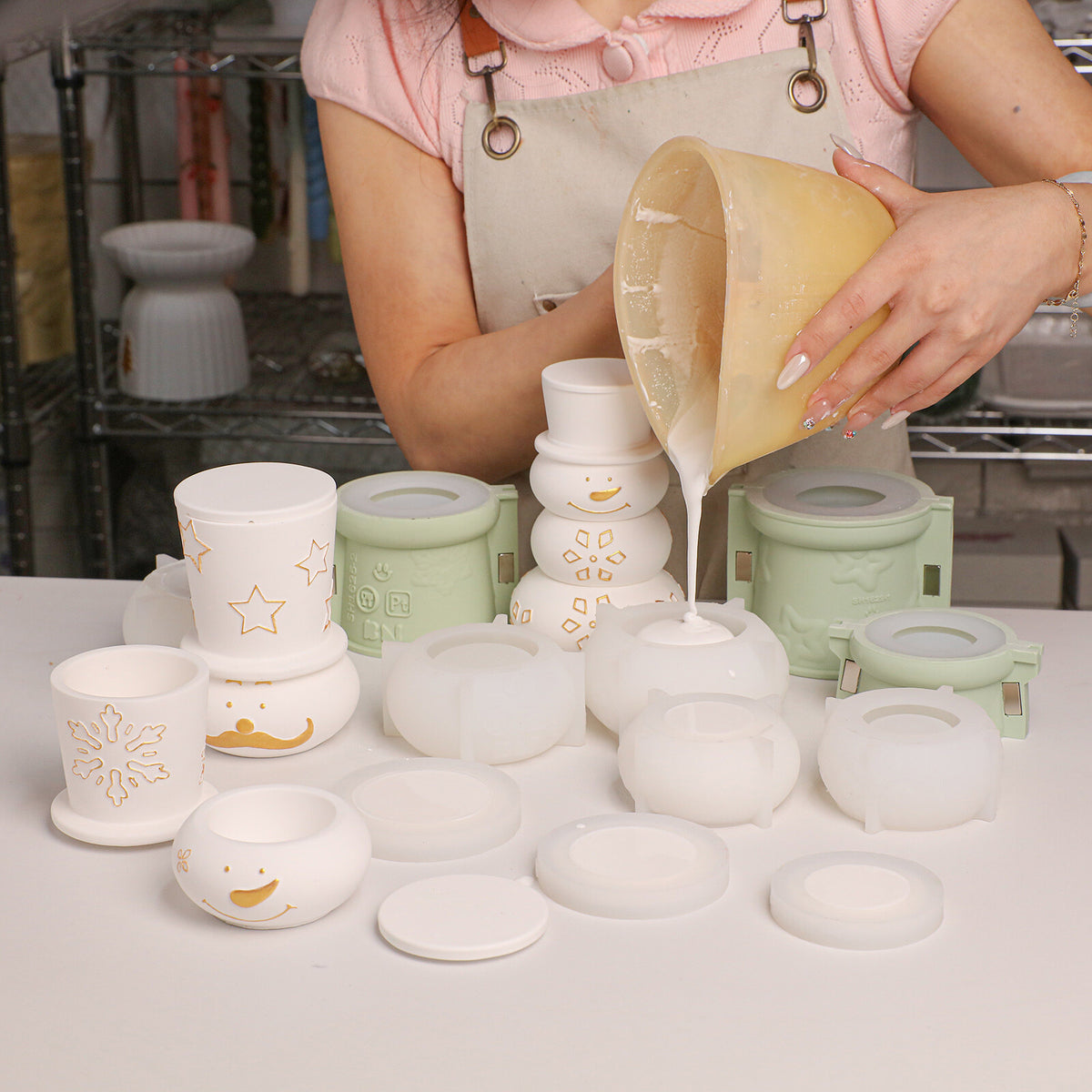 Pouring cement into snowman silicone molds with finished jars behind
