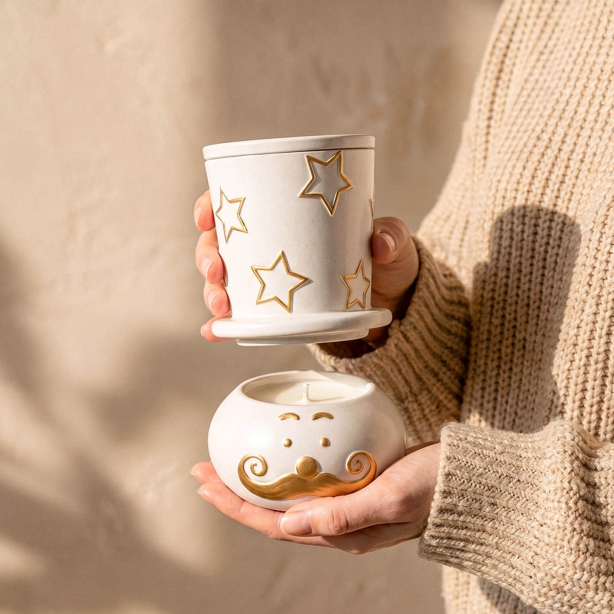 Hand holding a star snowman candle jar and moustache bowl