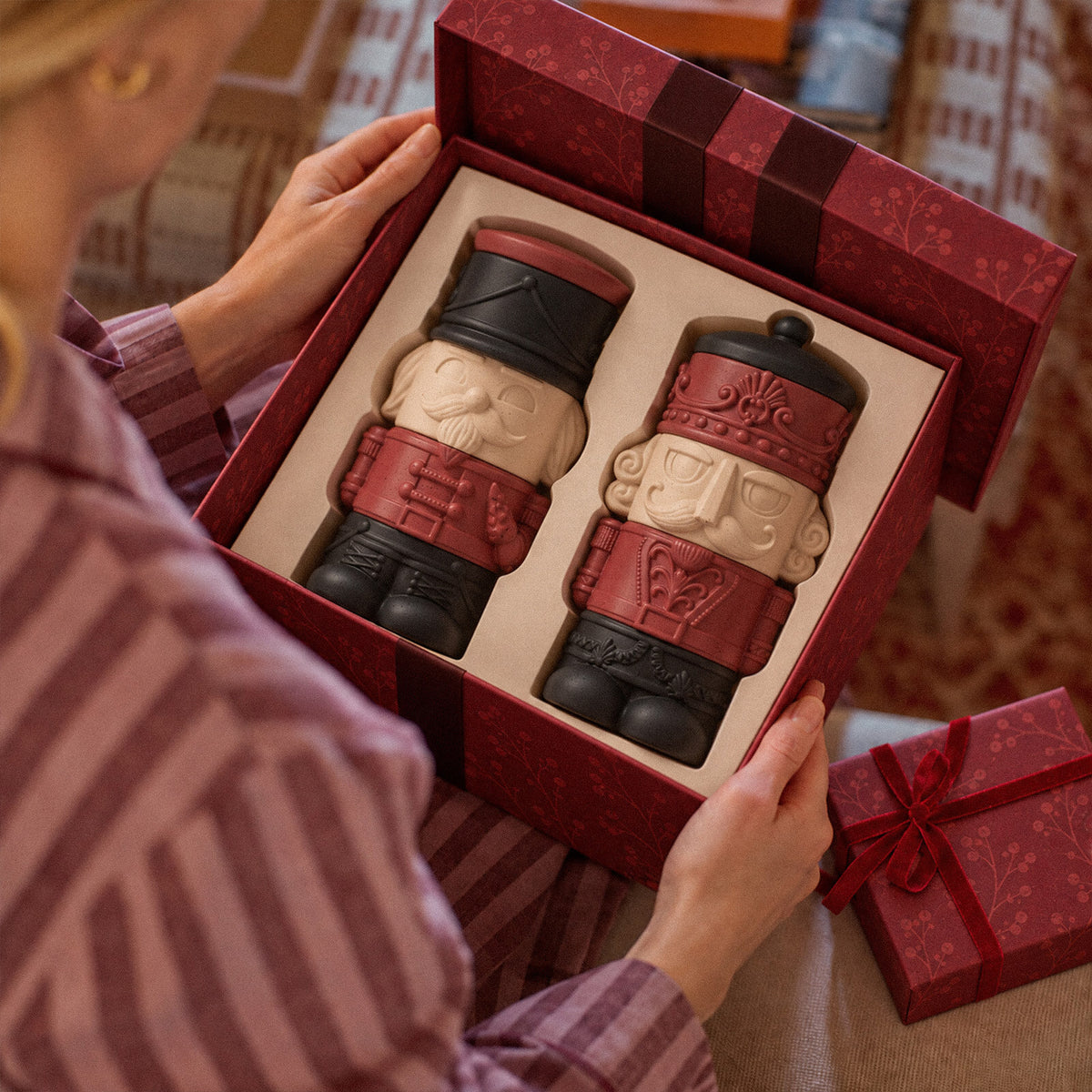 Red and cream nutcracker candle jars presented in a red Christmas gift box