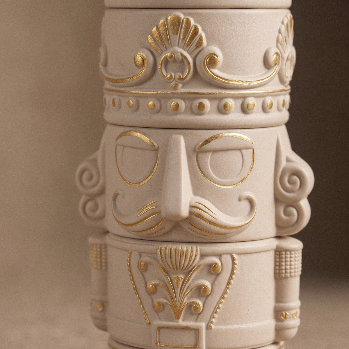 Lit cream nutcracker candle jars with gold painted details