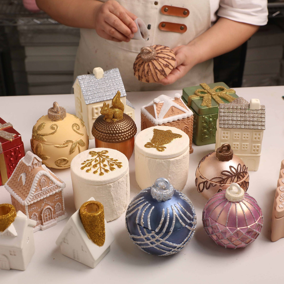 Crafter decorating plaster Christmas ornaments with eco glitter