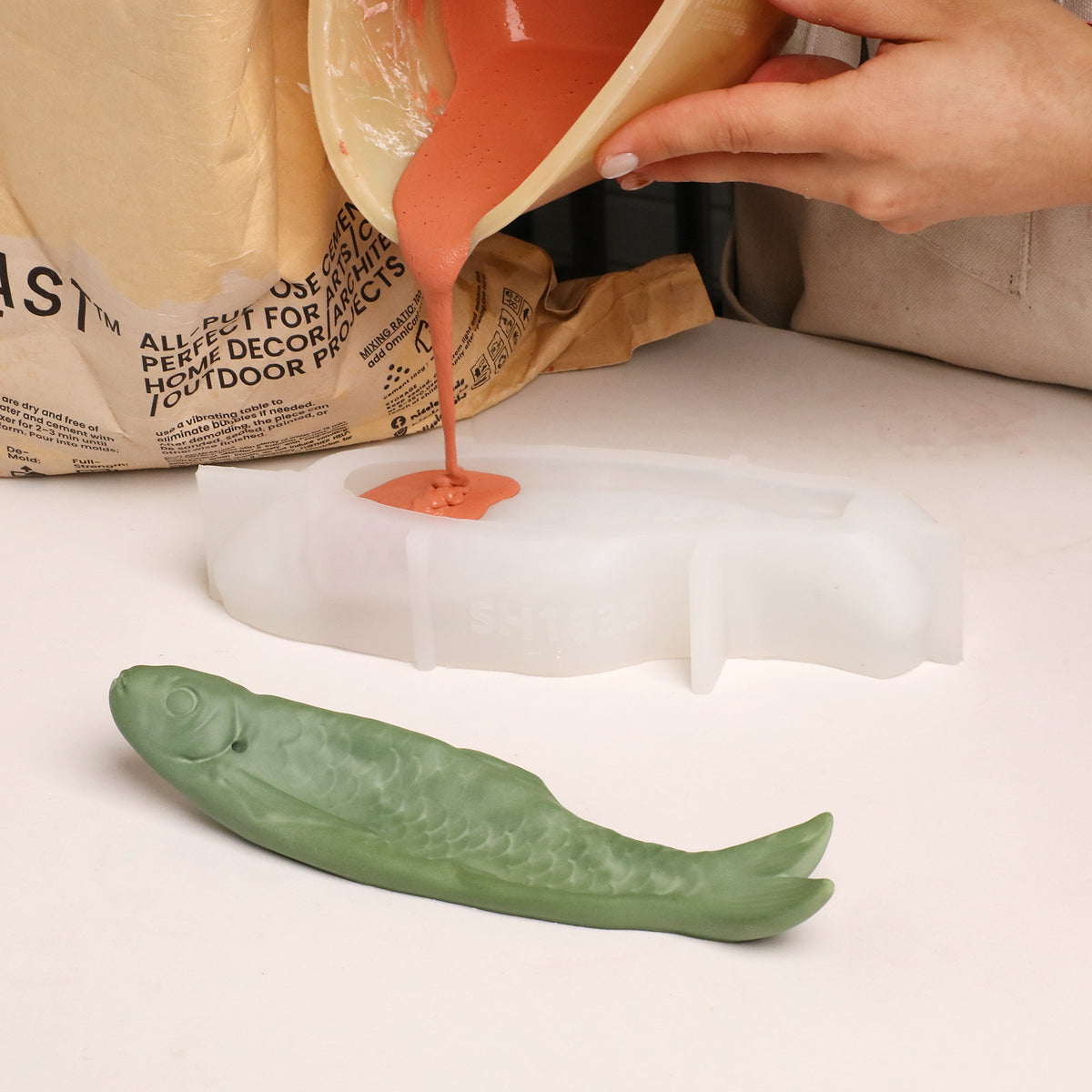 Pouring coloured casting material into the fish-shaped silicone mold