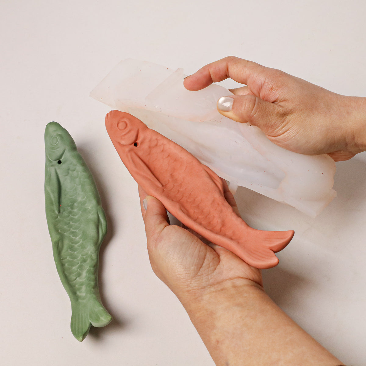 Demolding a terracotta-coloured fish incense holder from flexible silicone