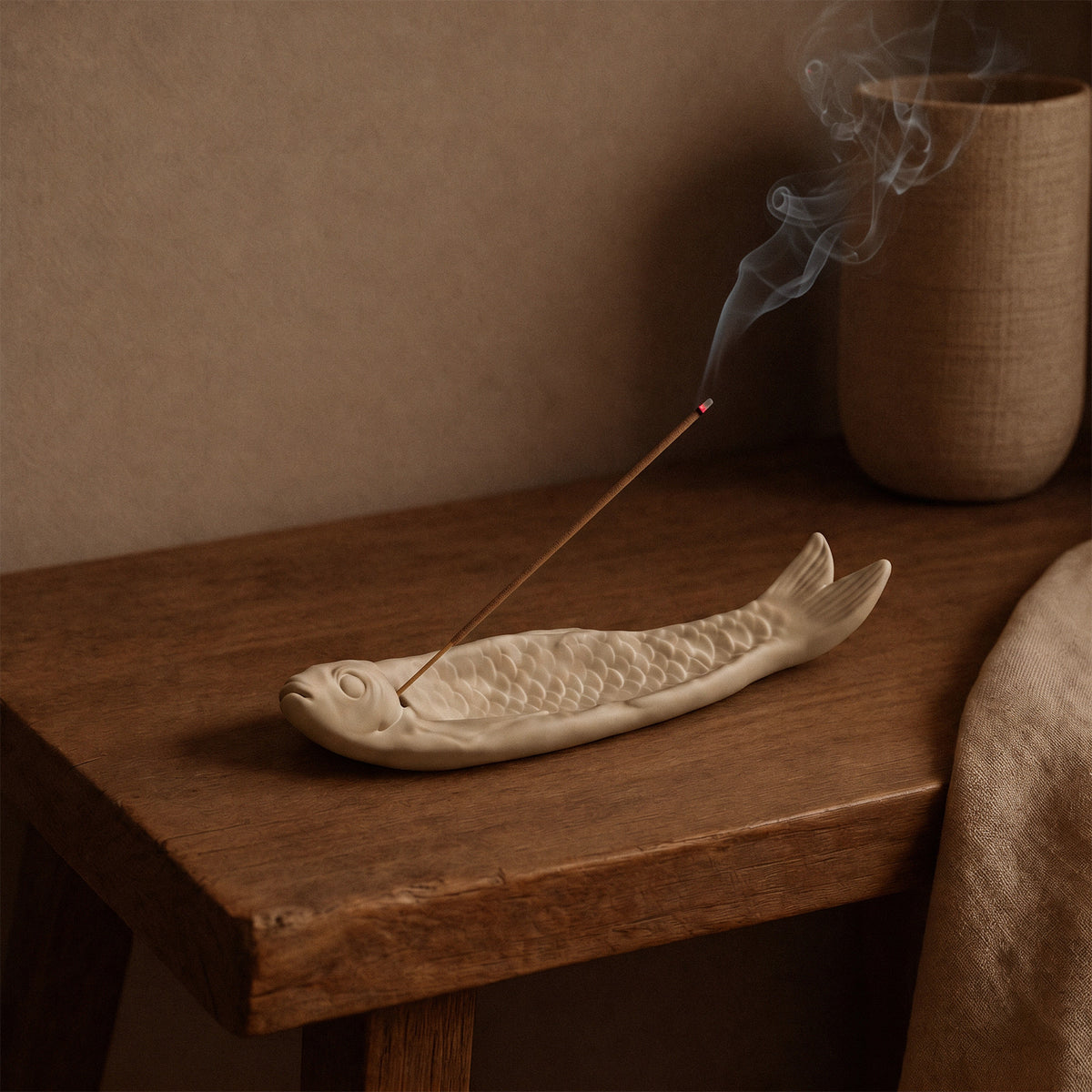 Burning incense displayed above the detailed fish-shaped holder