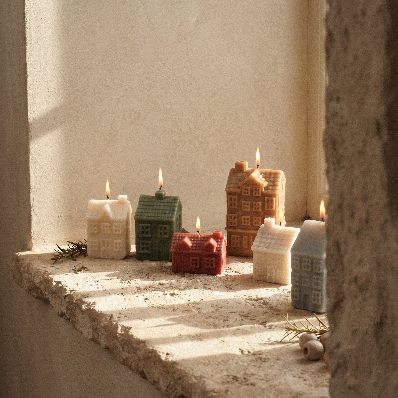 Little Winter Village candles on a sunlit windowsill