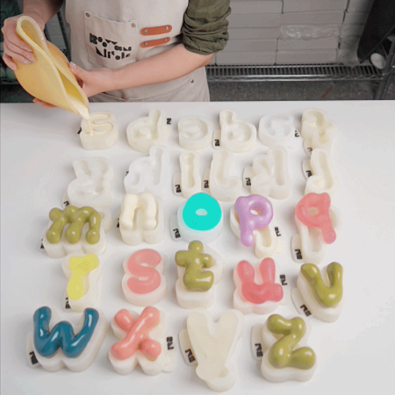Pouring casting mixture into lowercase alphabet silicone molds
