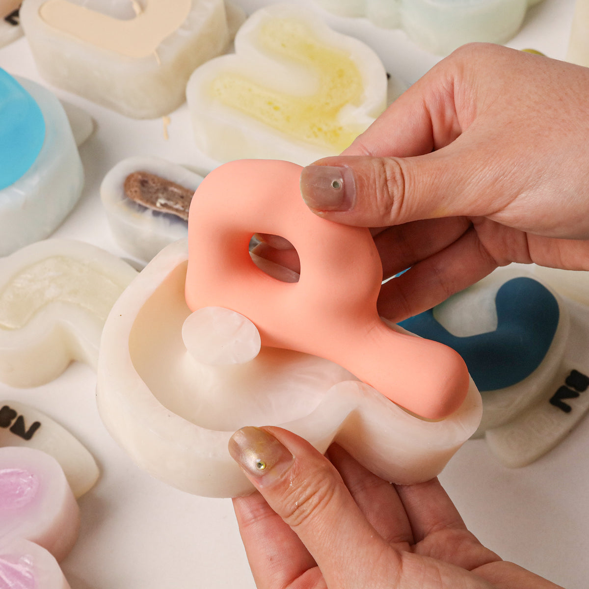 Demolding a pink lowercase letter from a flexible silicone mold