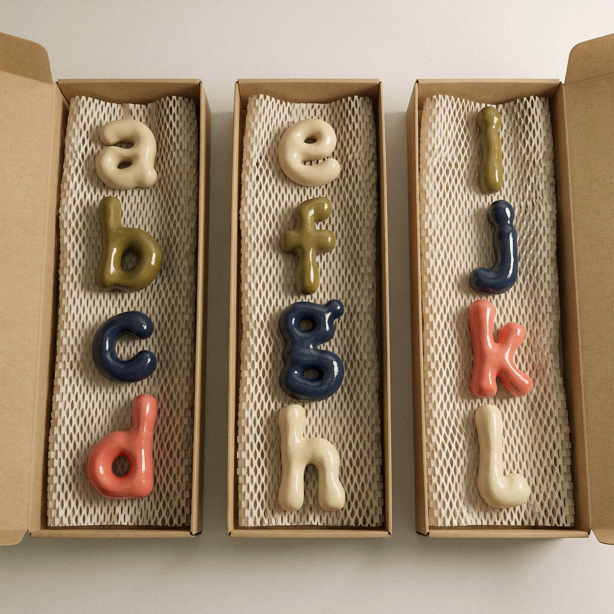 Painted lowercase alphabet ornaments presented in gift boxes