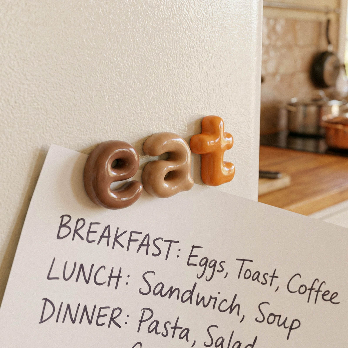 Handmade lowercase letters spelling eat above a meal planning board
