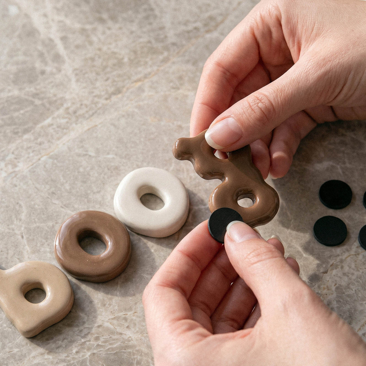 Attaching a small round magnet to the back of a cast lowercase letter