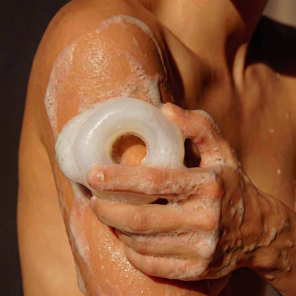 Cream lowercase letter soap being used in a shower