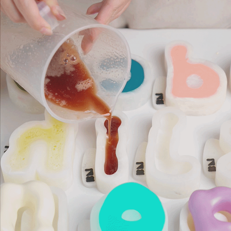 Demolding colorful lowercase letter soaps from flexible silicone molds