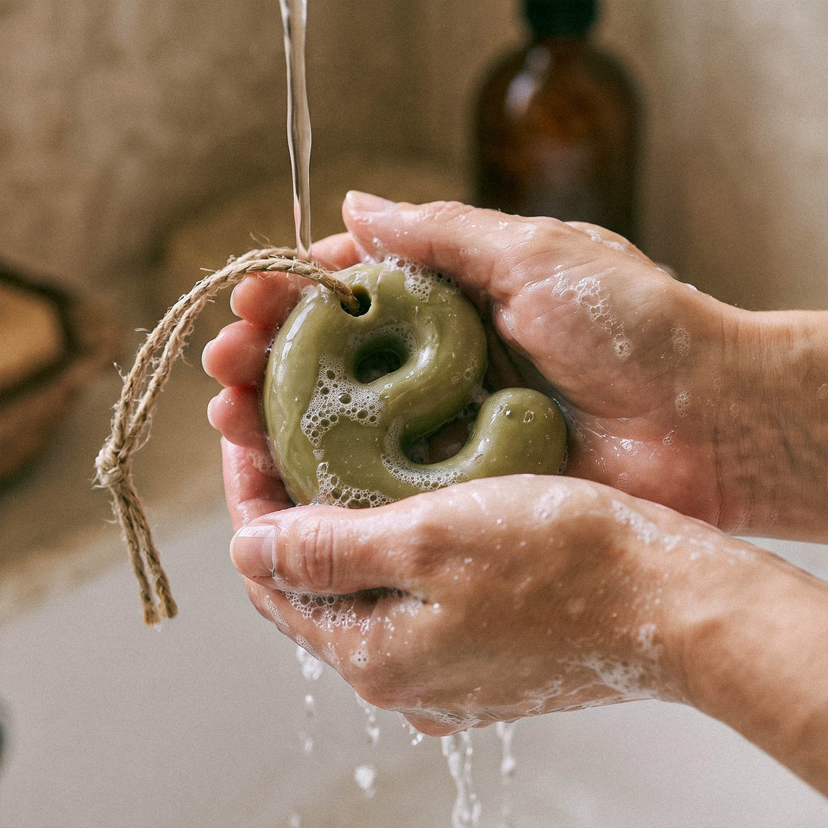 Washing hands with a green lowercase letter soap