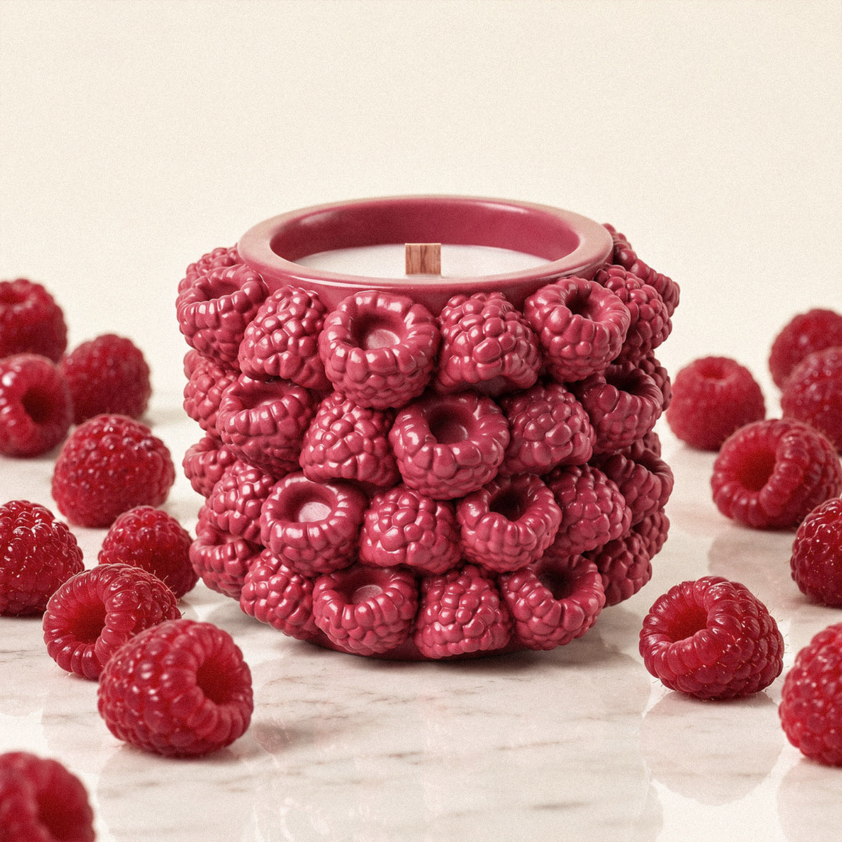 Raspberry-textured candle jar with a wooden wick surrounded by raspberries