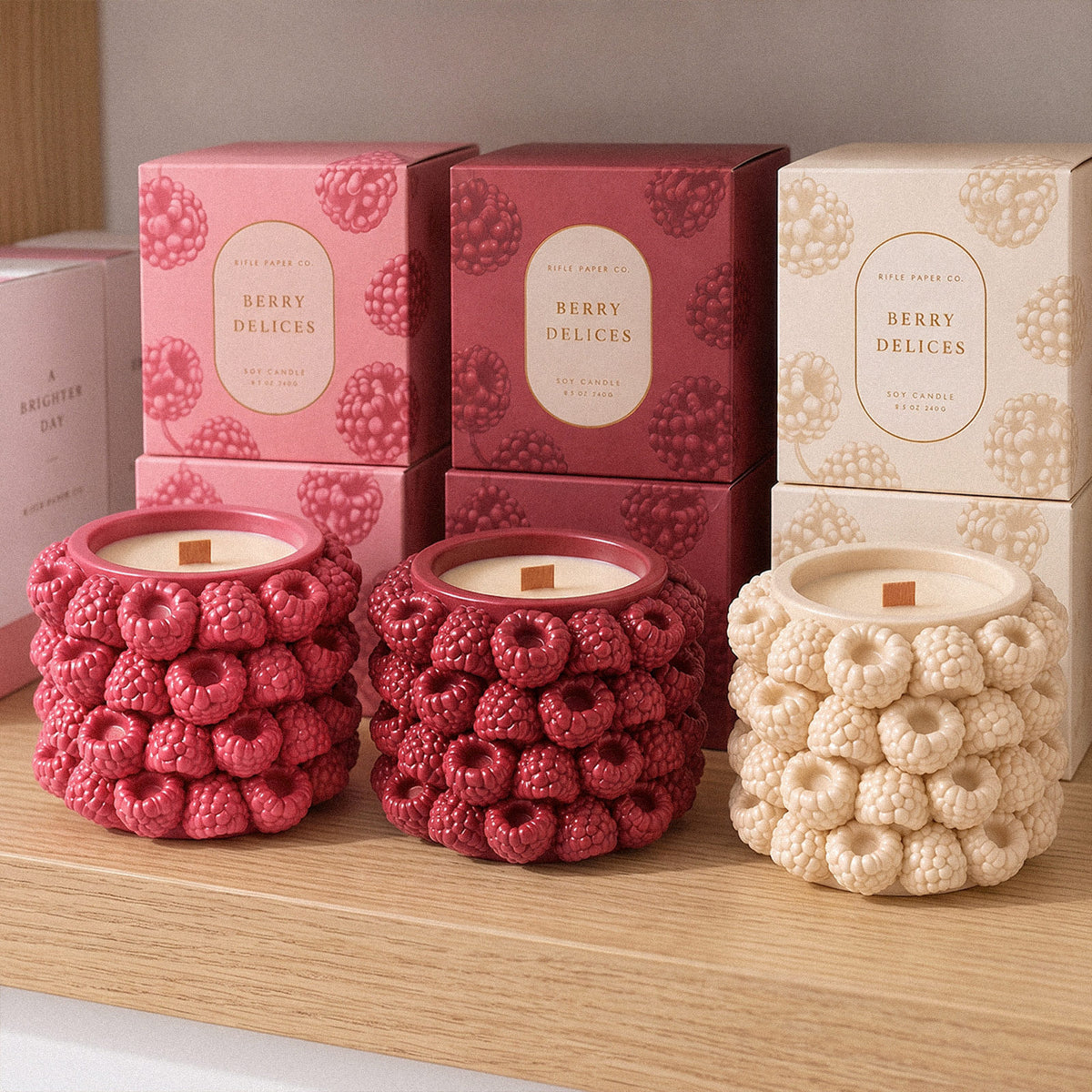 Raspberry candle jars in pink and cream displayed with gift boxes