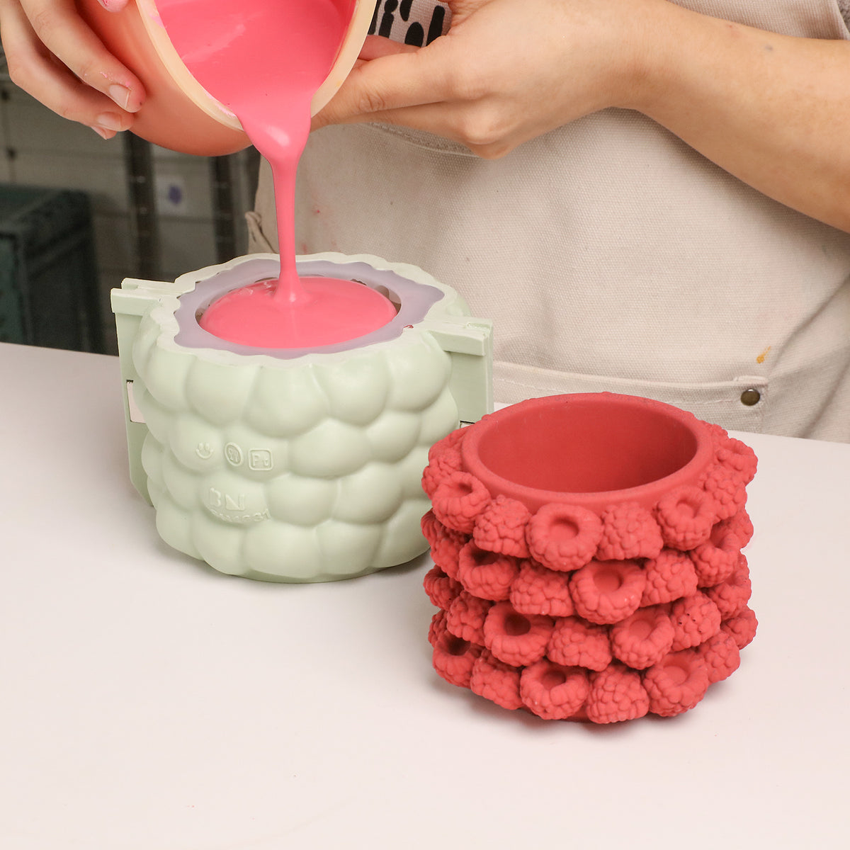 Pink casting material poured into the raspberry candle jar silicone mold