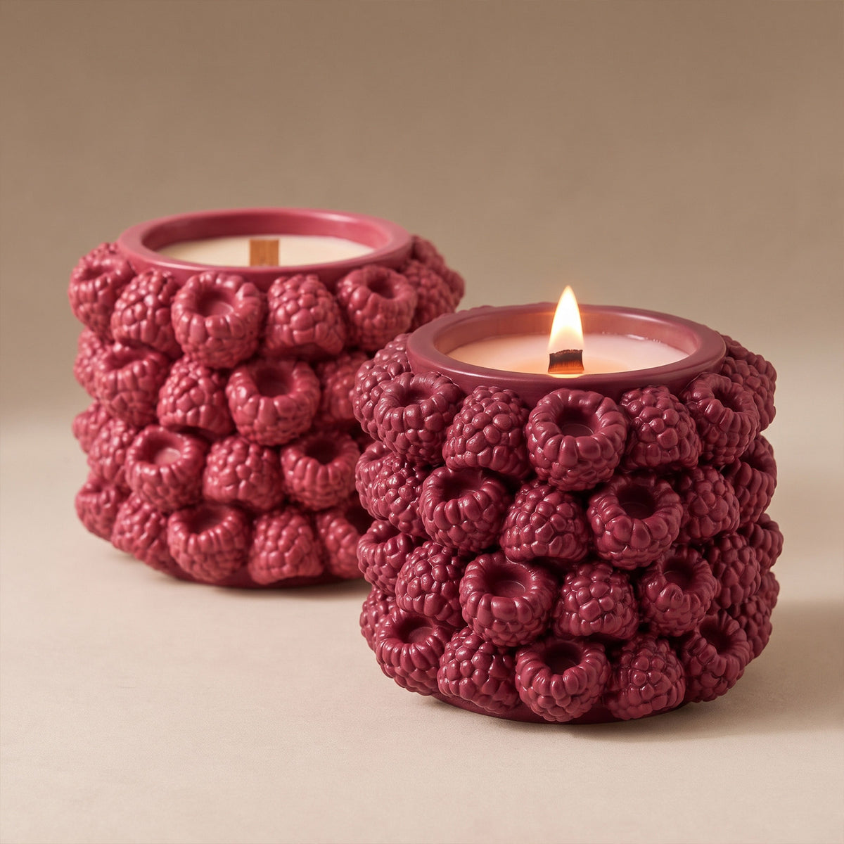Two lit raspberry candle jars in different berry shades
