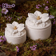 Rossella x Boowan Nicole Eterna Hibiscus candle jars in white on a garden moss bed
