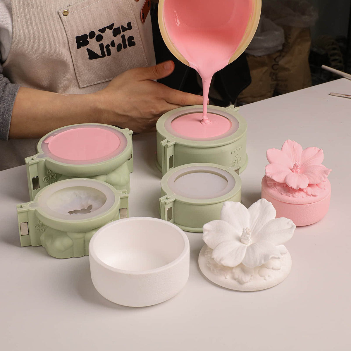 Pouring pink cement into the jar body and lid molds