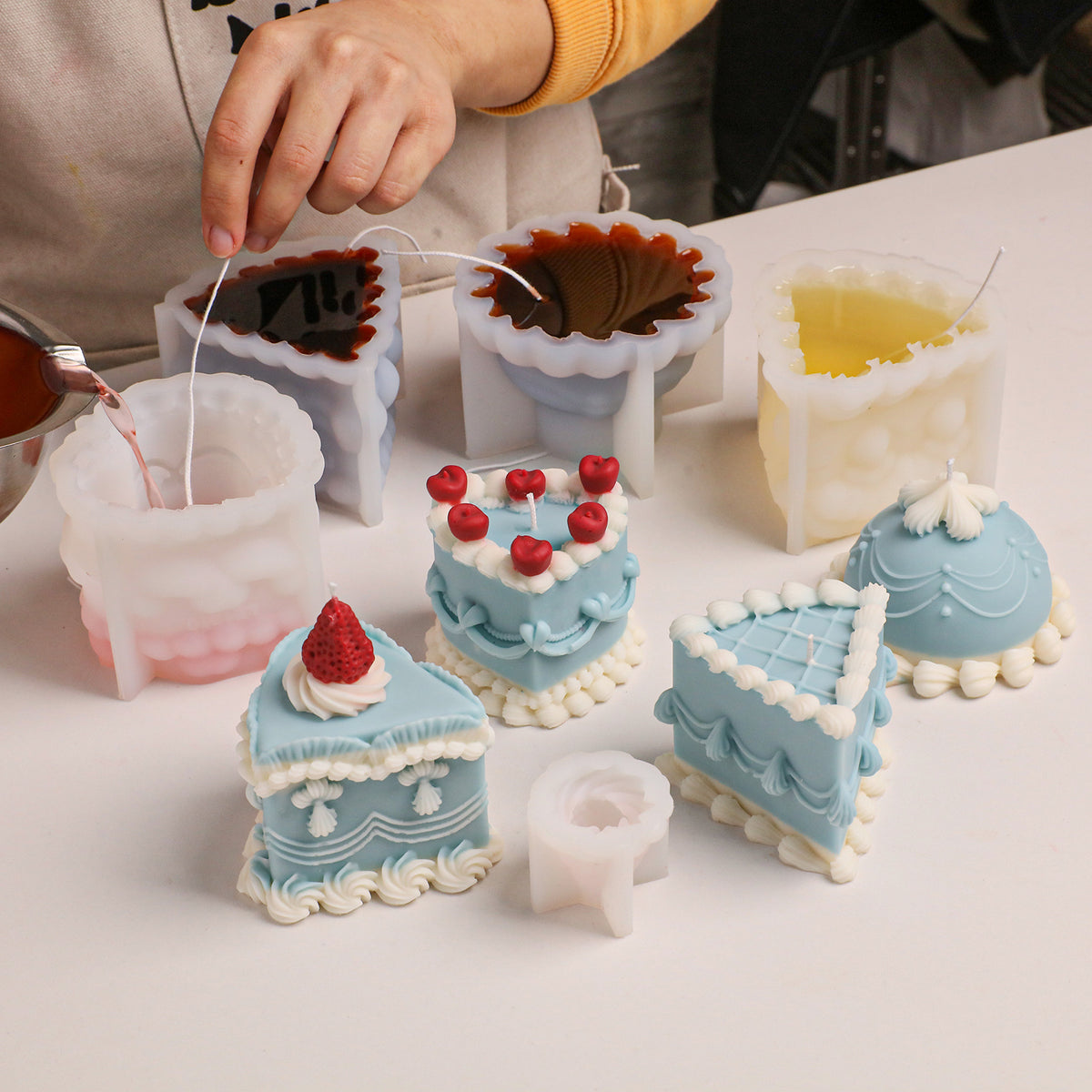 Cake candle molds and freshly poured candles on a craft table