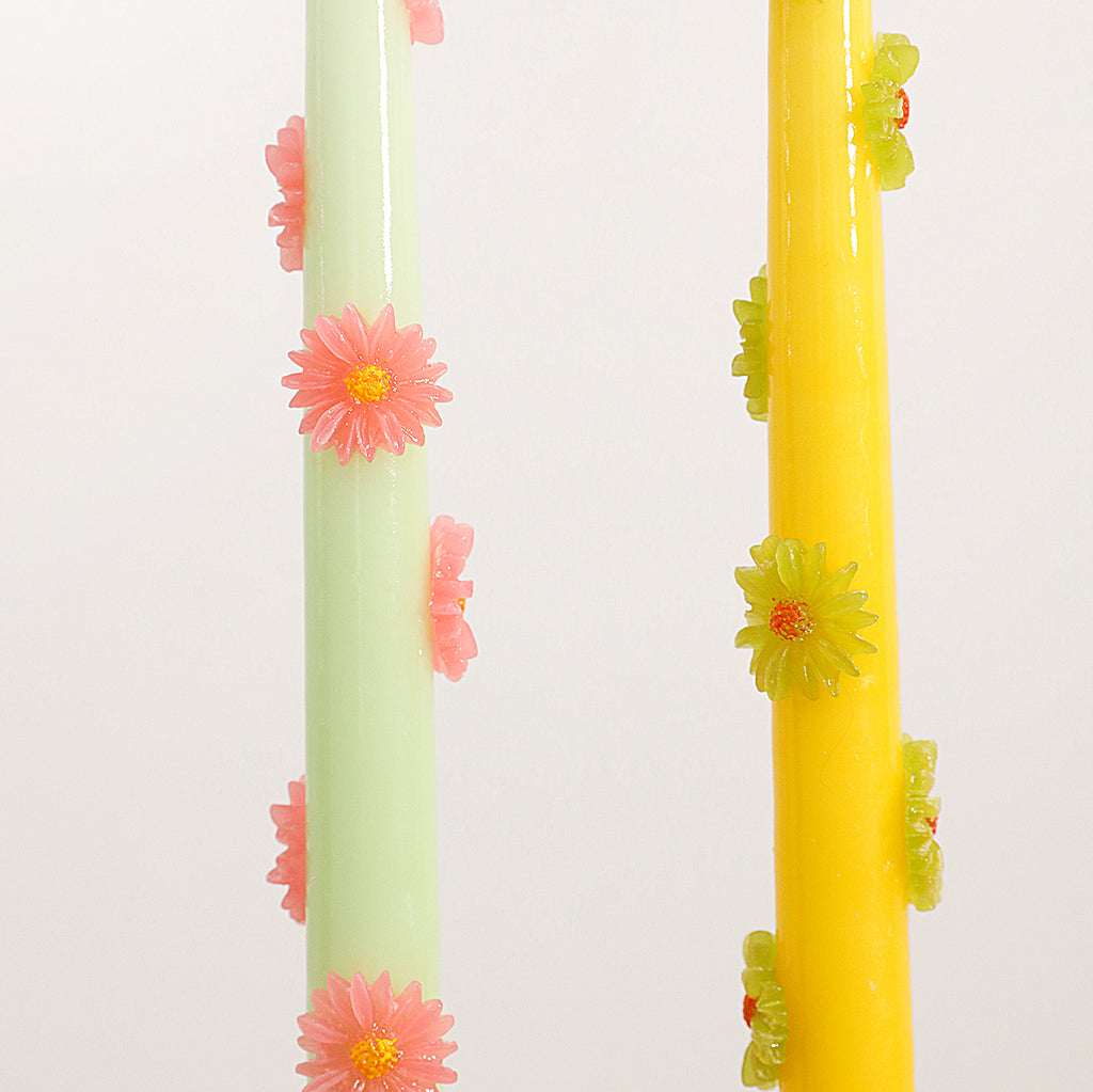 Close up view of teal and yellow taper candle with daisy decoration showing design details - Boowan Nicole