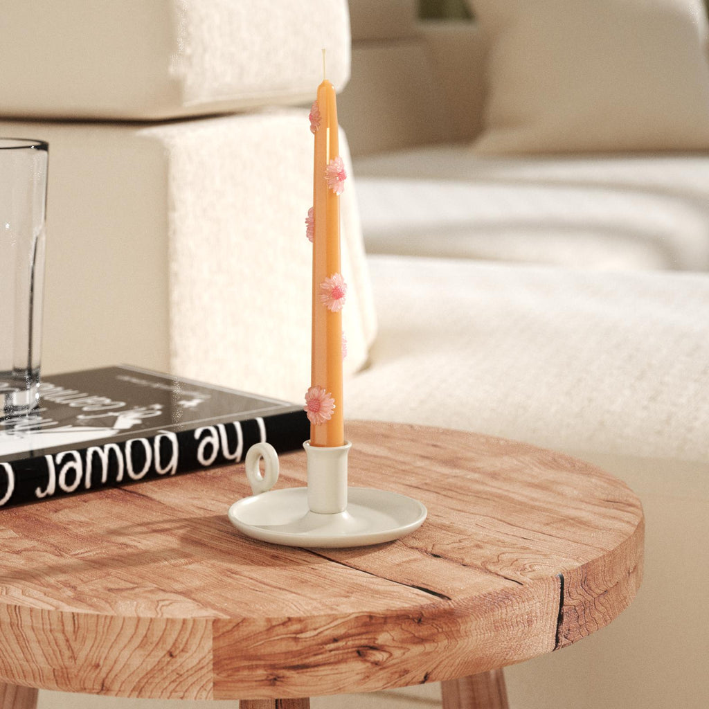 Yellow-brown daisy taper candles on white candlesticks on tabletop-Boowan Nicole